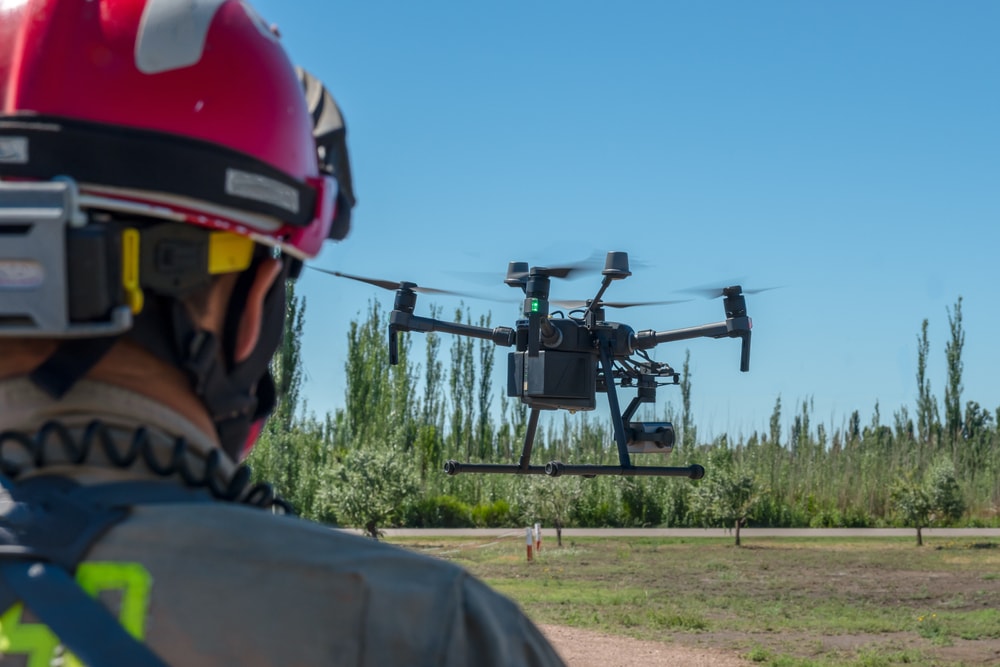 Firefighter piloting a rescue drone in a field