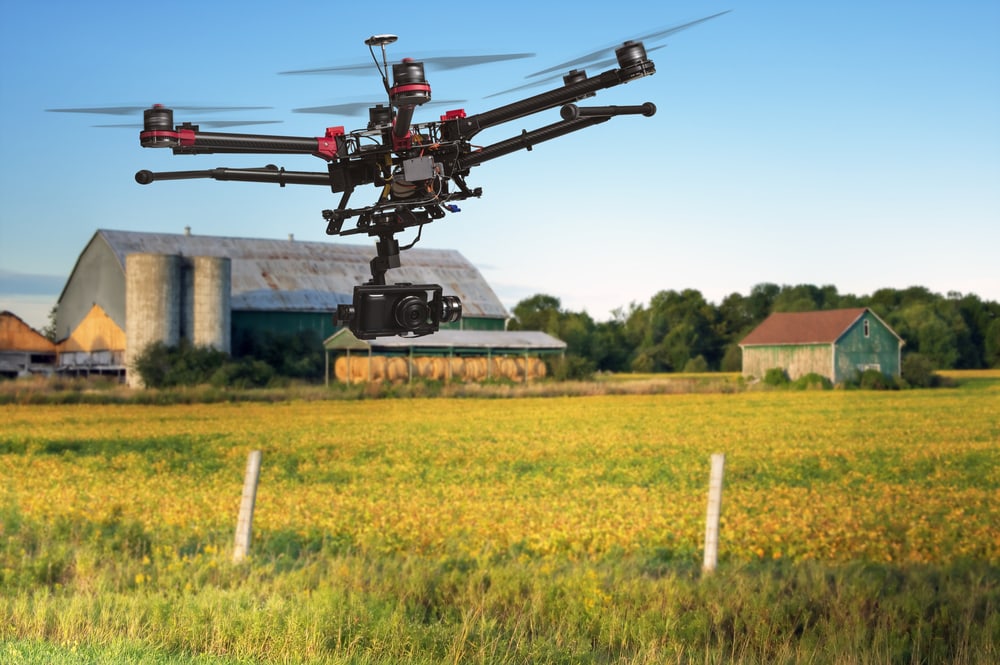 Drone flying with raised landing gears over farm